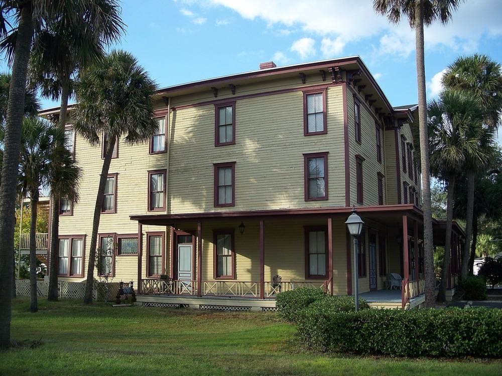 The side of the Longwood Hotel, with its long porch and tall palms